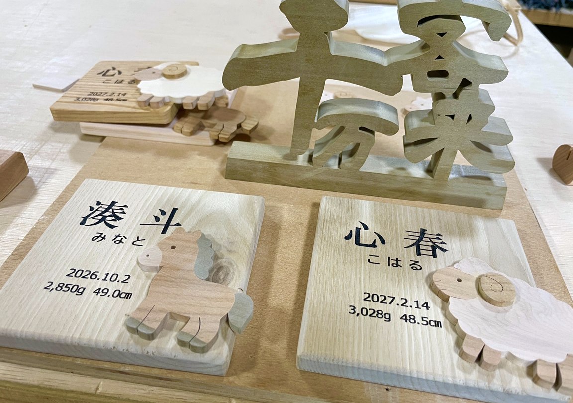 誕生の記録のプレートと、千客万来の切り文字